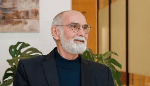 Vyresnio amžiaus vyras su akiniais klinikos aplinkoje